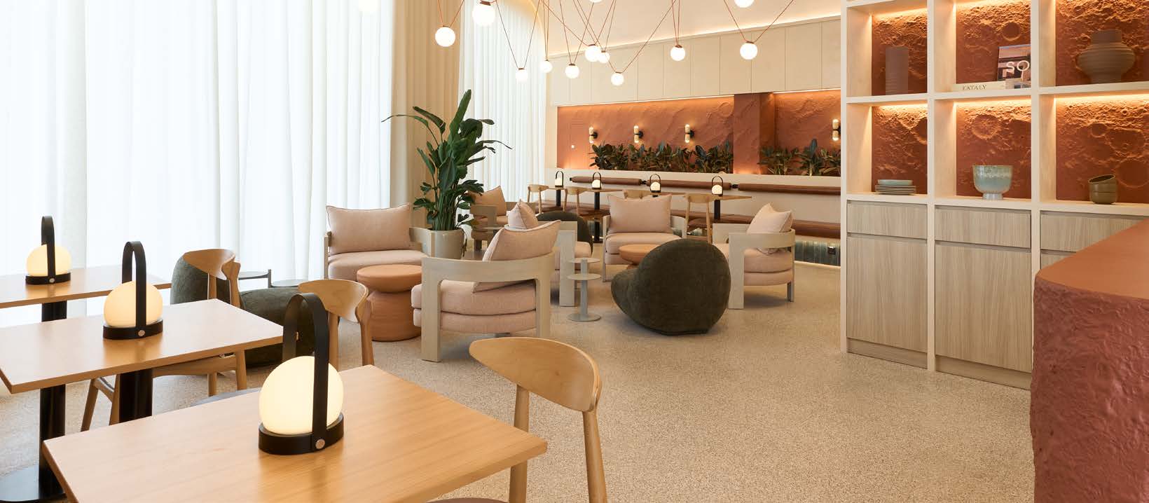 A hospitality lounge with a terracotta feature wall and sculptural seating