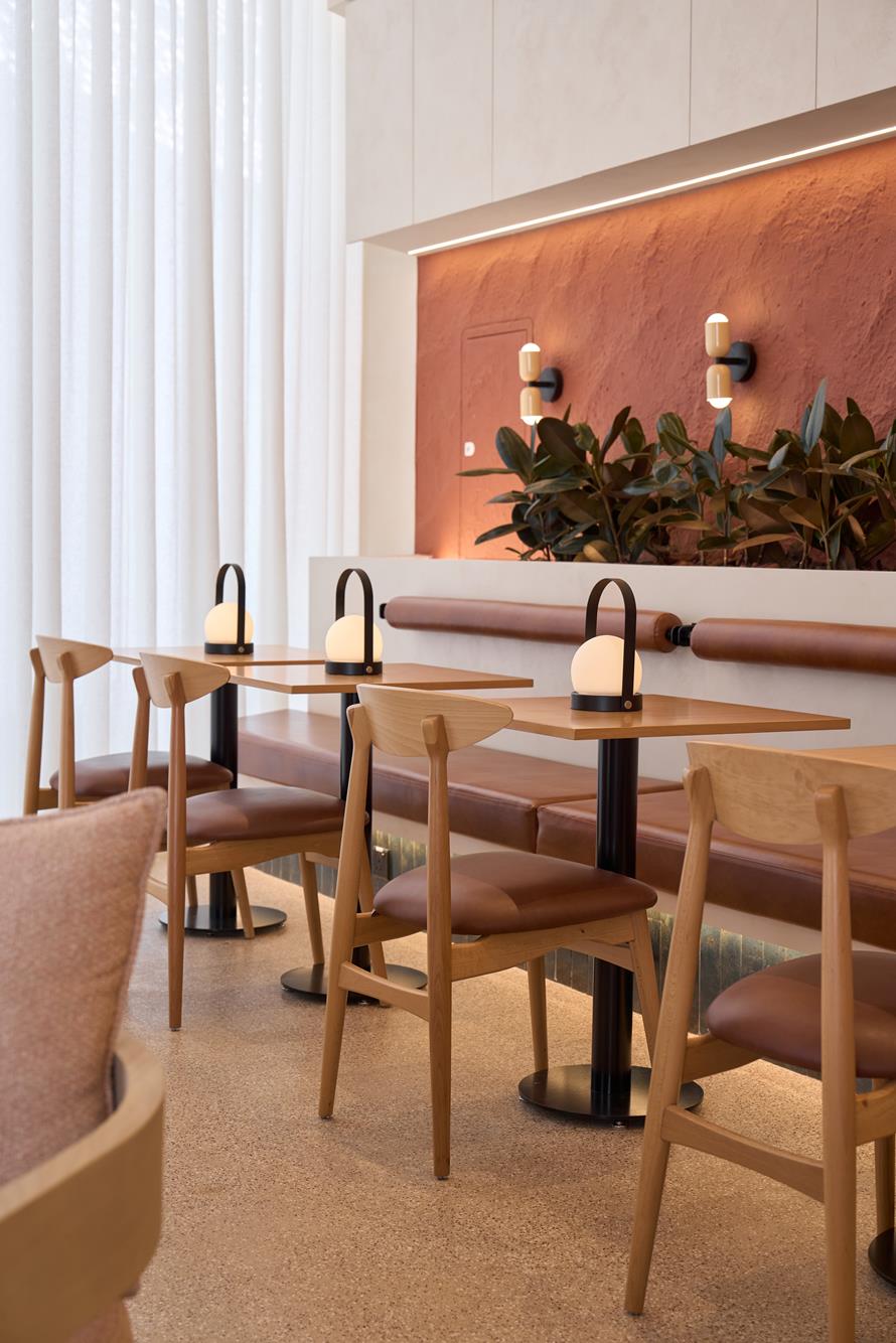 Oak chairs and leather banquette seating drawn up to small tables