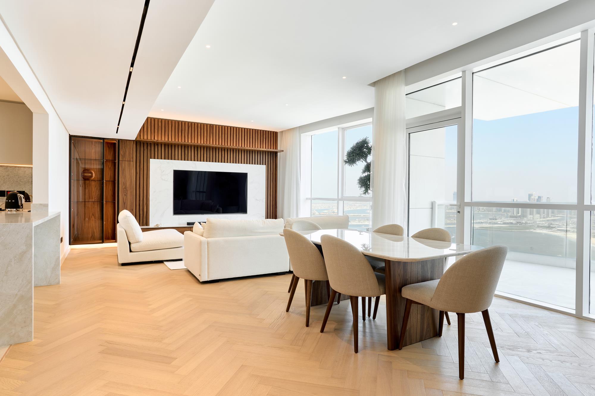 An open living and dining room in oak herringbone facing the Gulf
