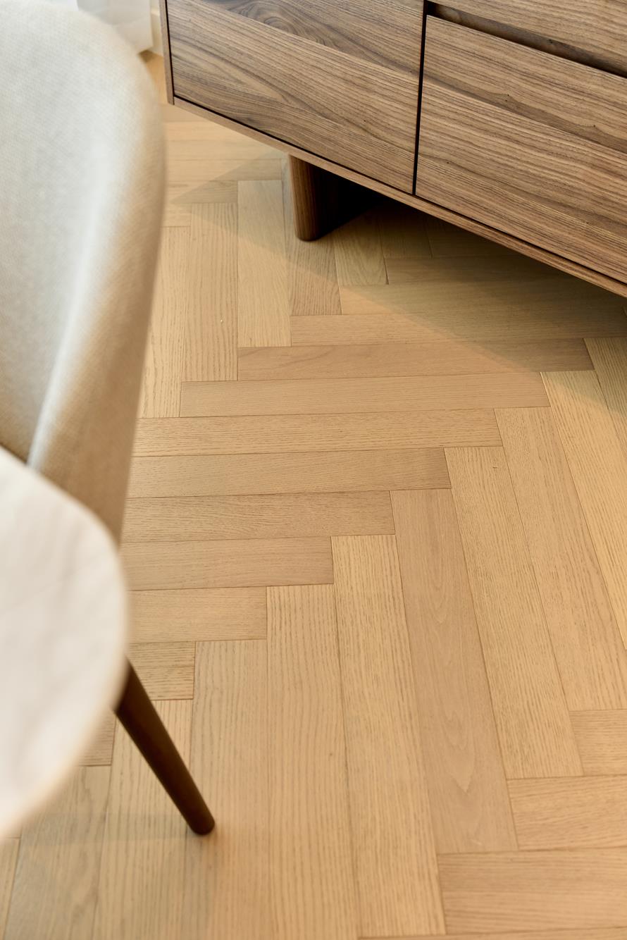 Oak herringbone flooring beneath a walnut credenza