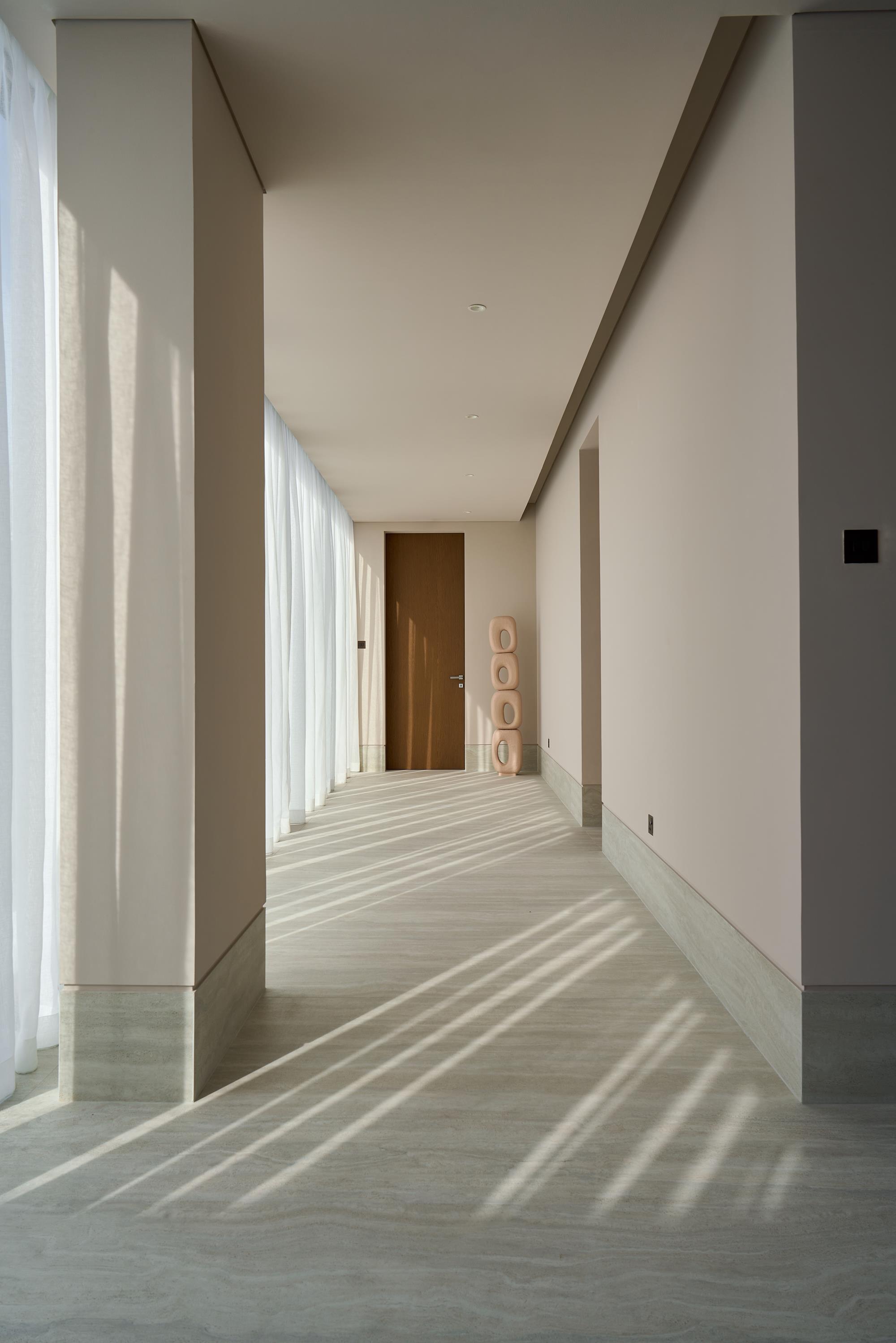 Travertine entrance gallery washed in raking daylight