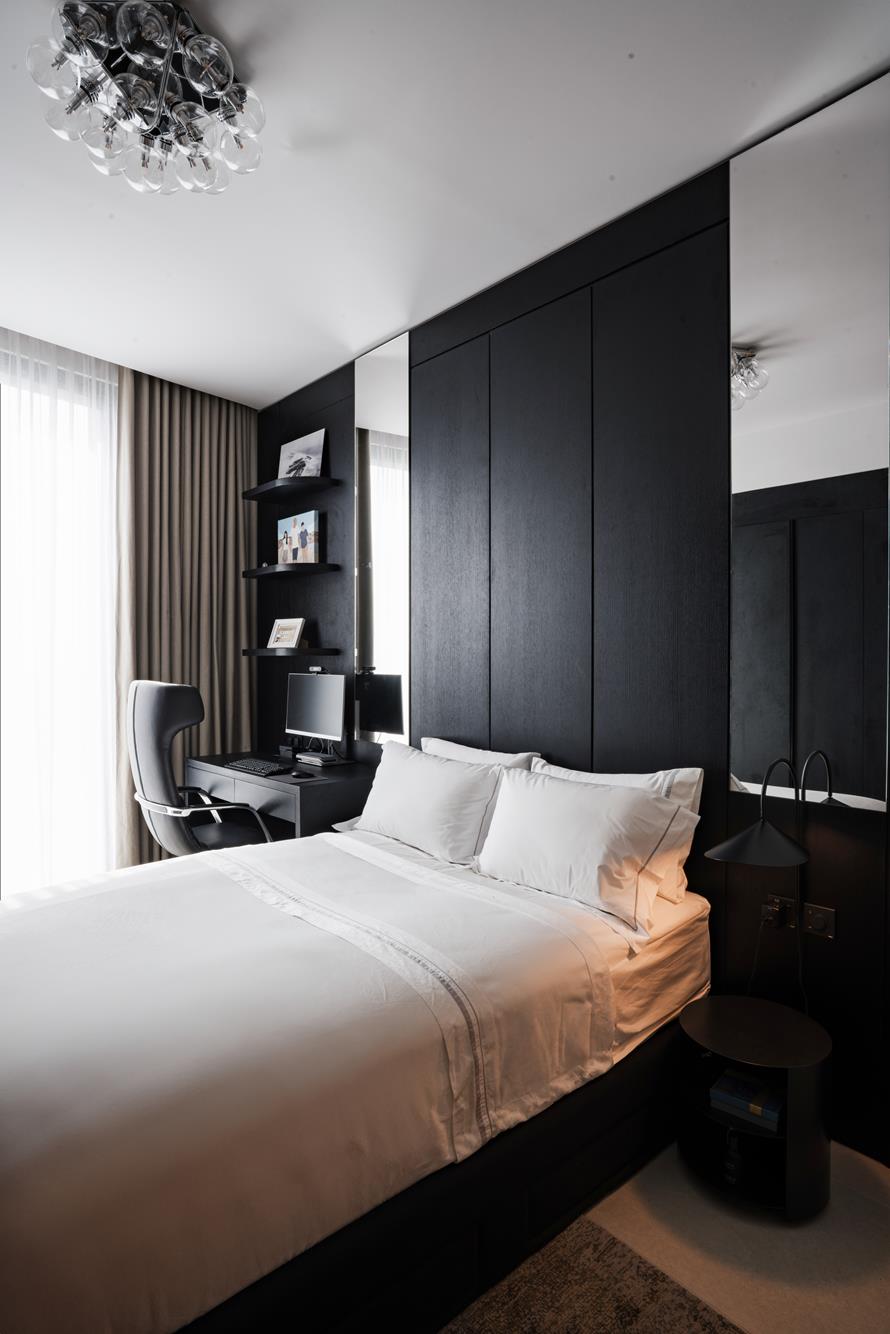 A bedroom panelled in blackened oak, desk and mirror folded into the wall