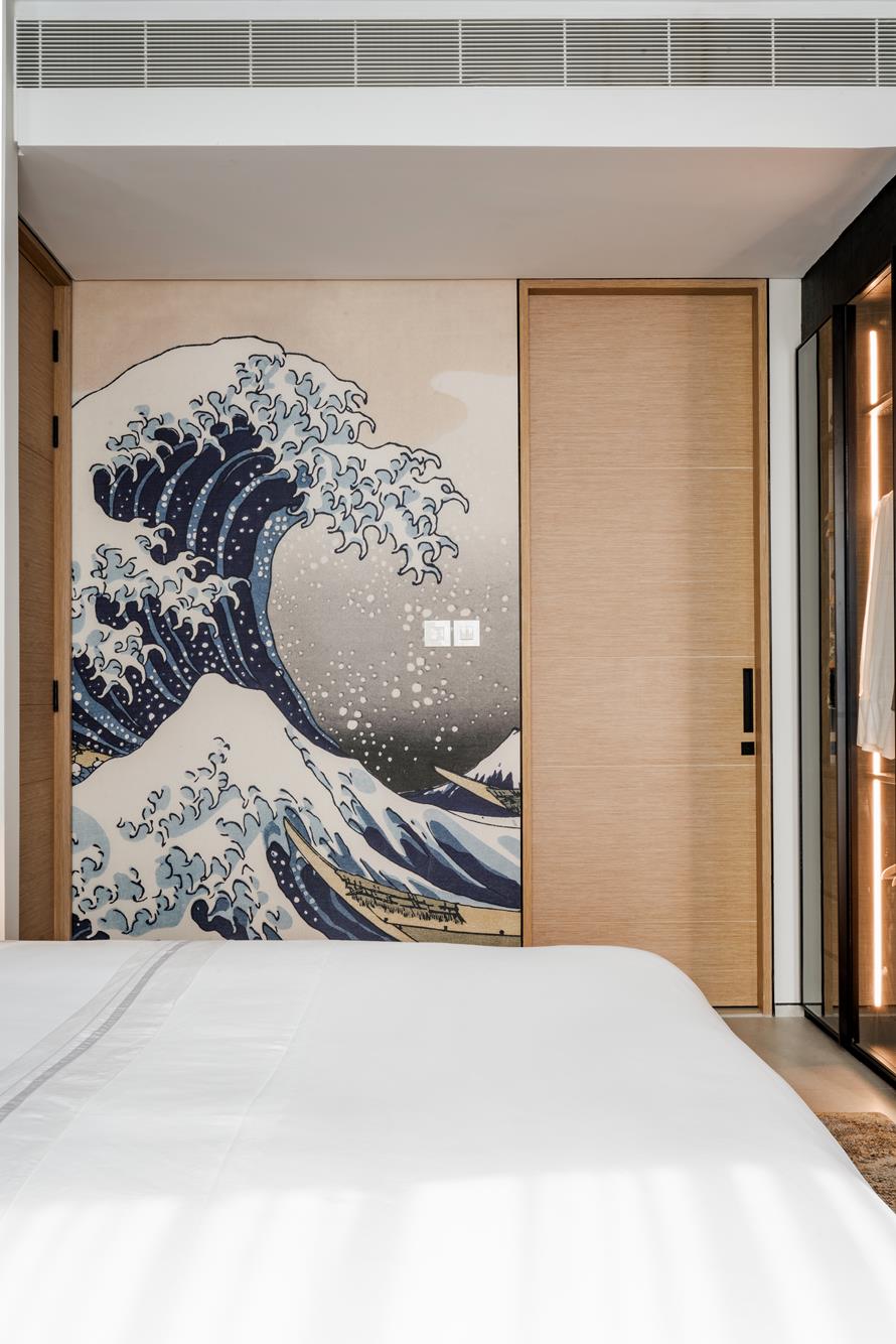A wall mural of Hokusai’s Great Wave beside oak sliding doors