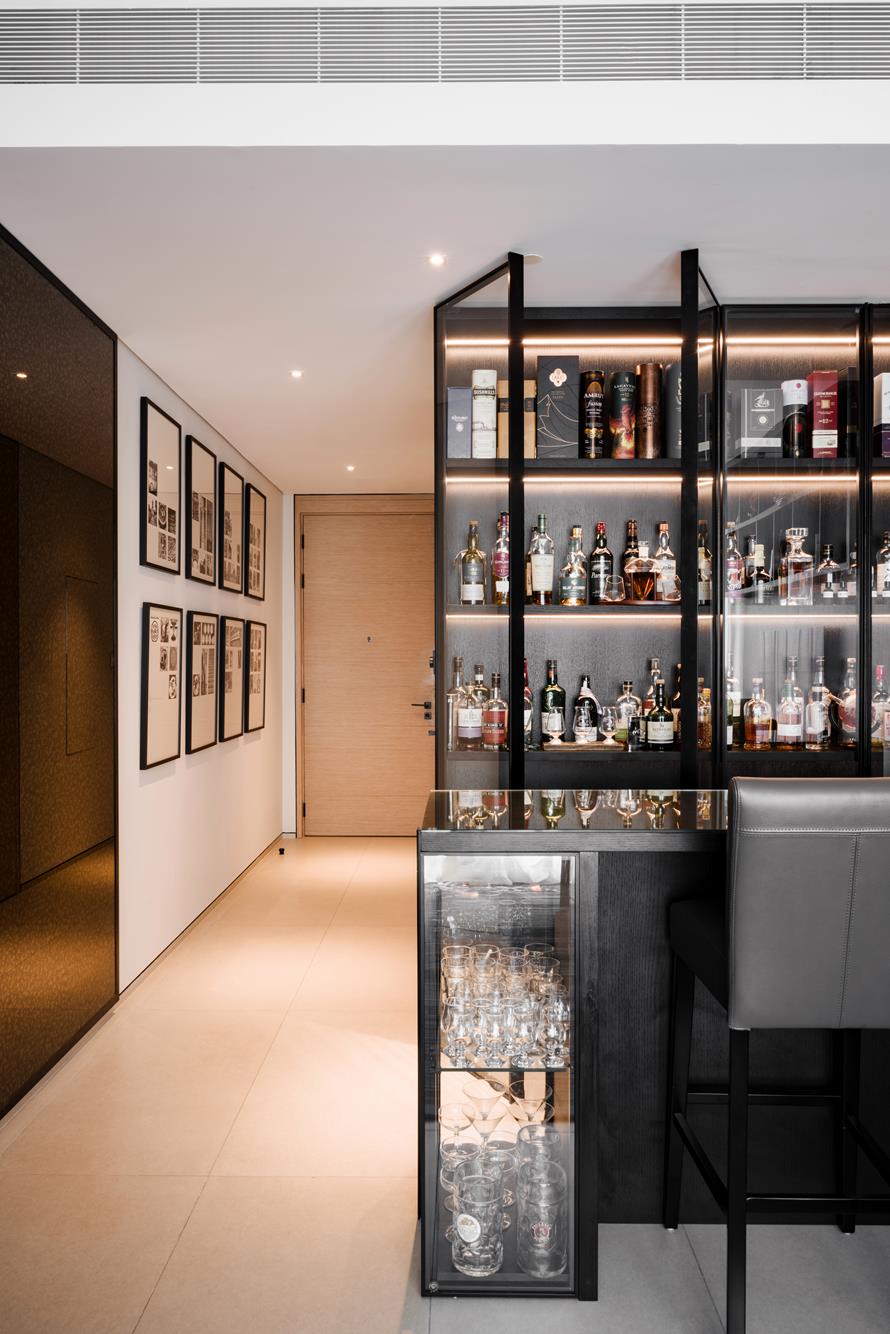 A lit display bar beside a corridor hung with framed prints