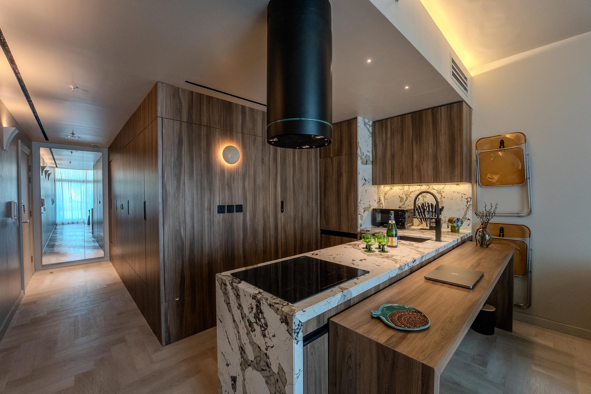 Open-plan living and kitchen in warm walnut and stone
