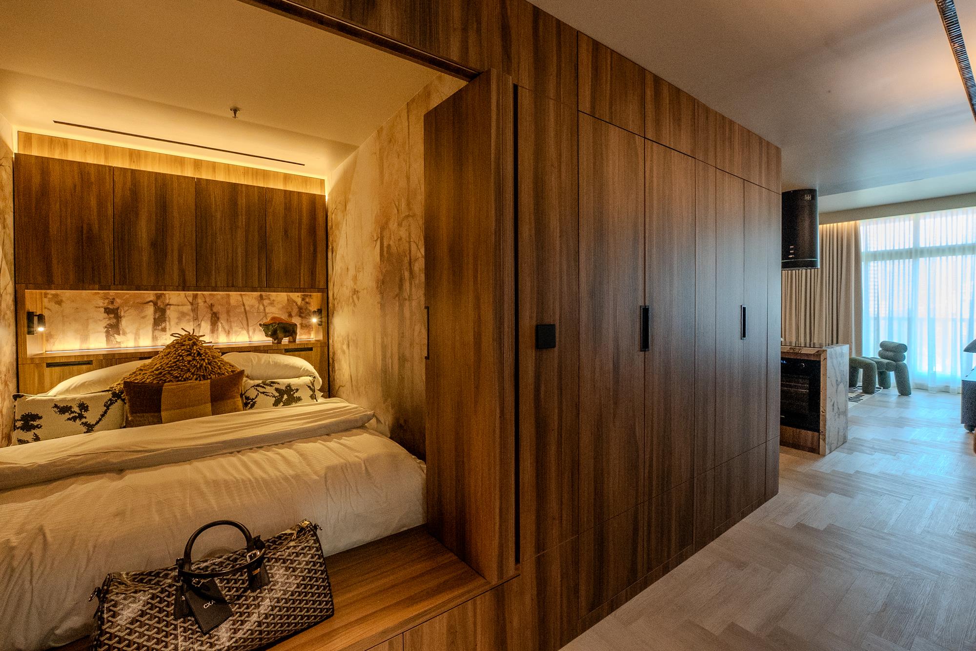 A continuous wall of American walnut joinery with concealed handles